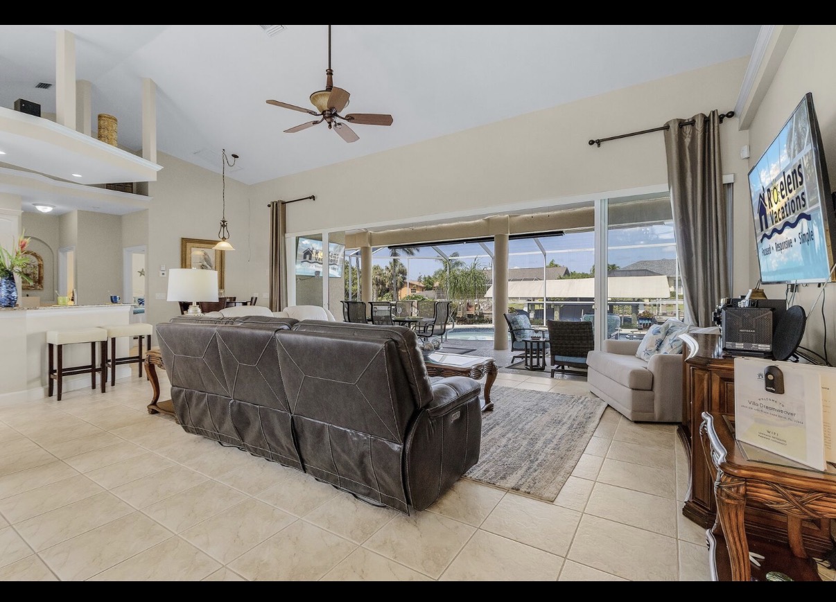 Open-concept living room with view to the lanai and pool